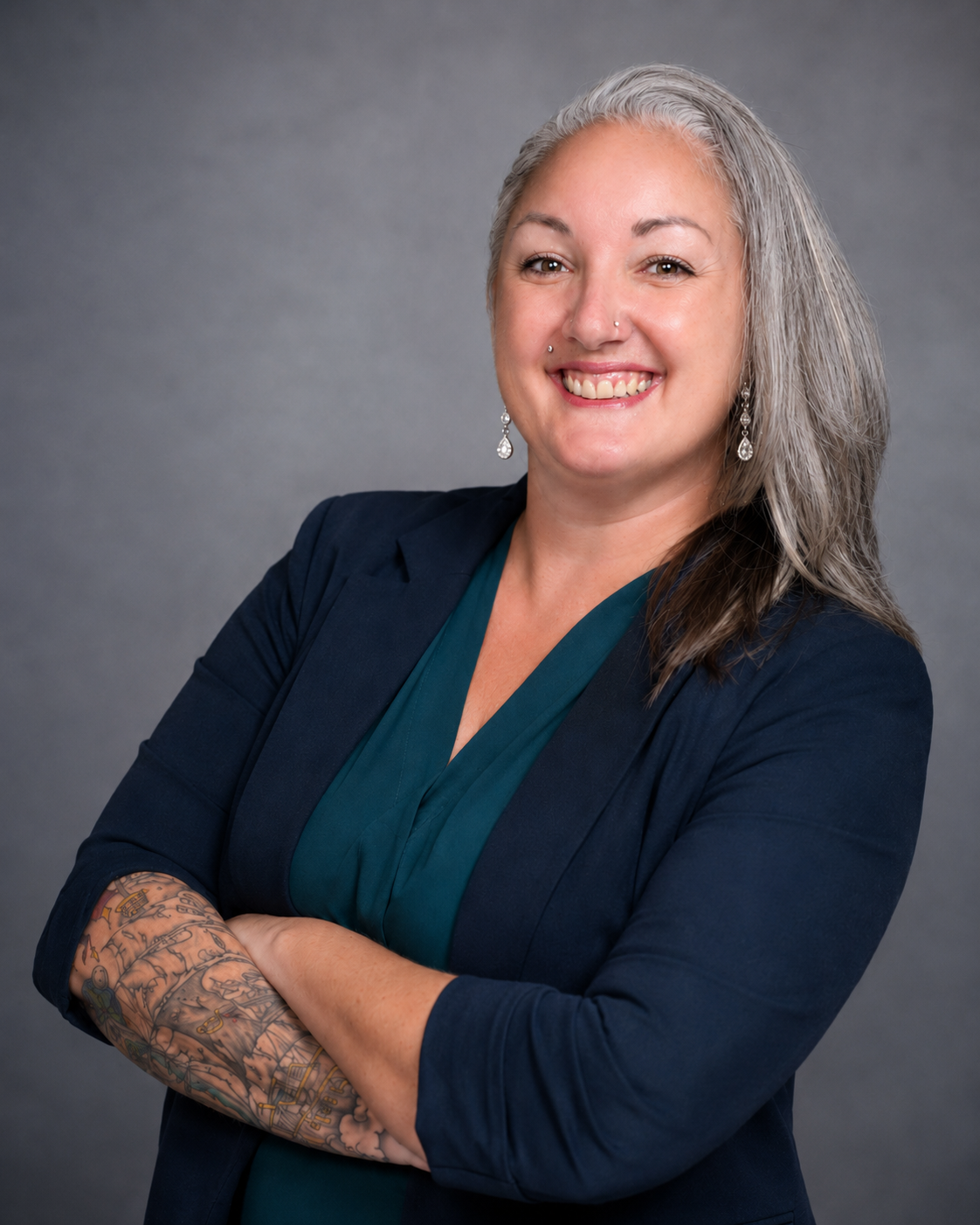 Misti King smiling with arms crossed in a professional portrait